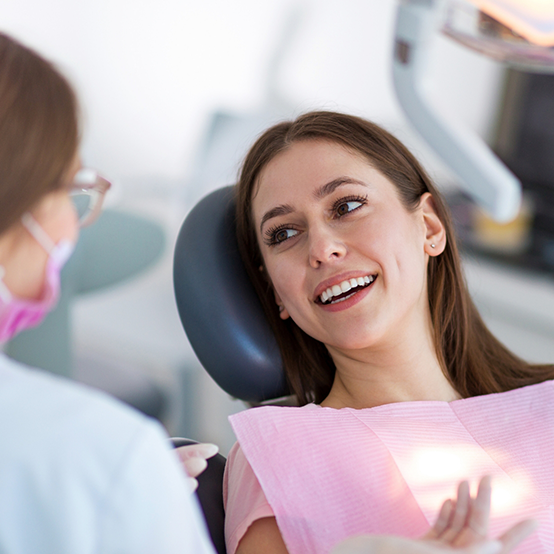 Woman in dental chair talking to her Jupiter dentist