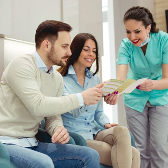 Dental team member discussing paperwork with patient