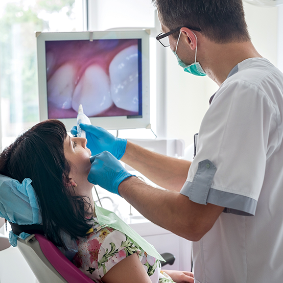 Dentist capturing photos of a patients mouth during a dental exam