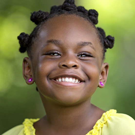 Young girl in yellow blouse grinning