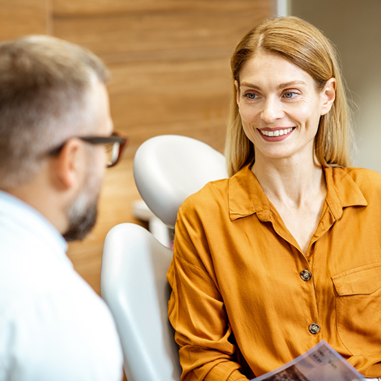 Woman in chair talking to her dentist in Jupiter