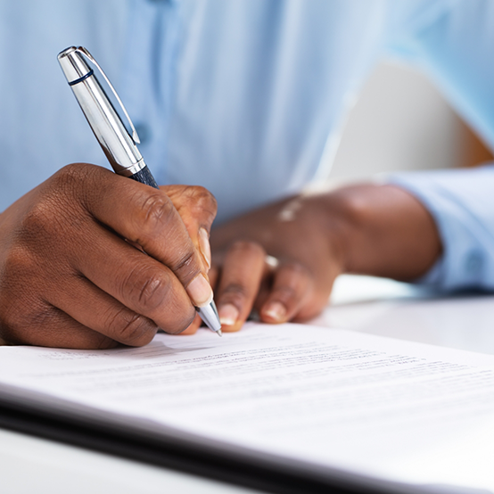 Person filling out form on clipboard