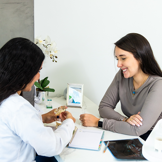 Woman talking to dental team member at front desk