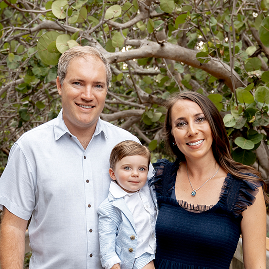 Doctor Rodriguez with his wife and young son with trees in background