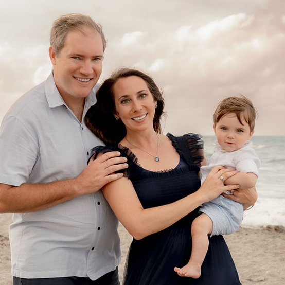 Doctor Kaitlin at the beach with her husband and young son