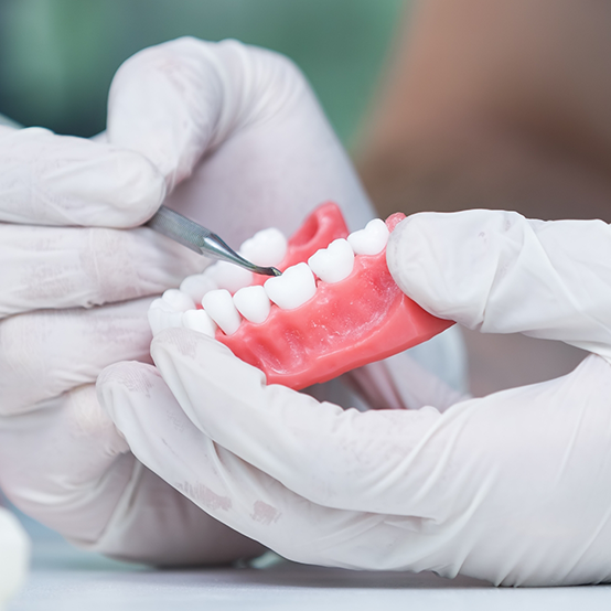 Ceramist crafting a denture