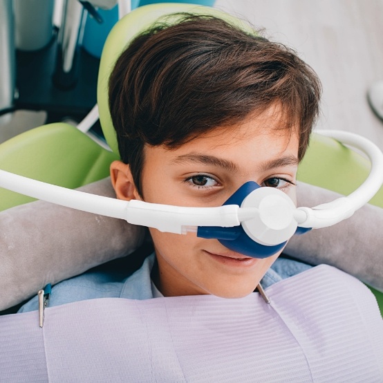 Young boy in dental chair with nose mask for nitrous oxide sedation dentistry