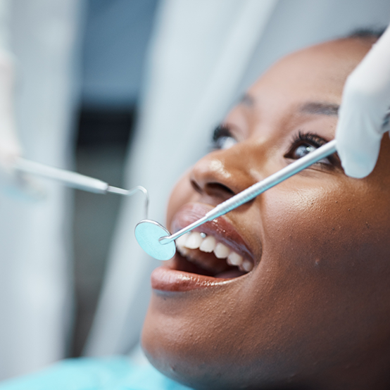 Woman in dental chair smiling right before receiving gum disease treatment in Jupiter